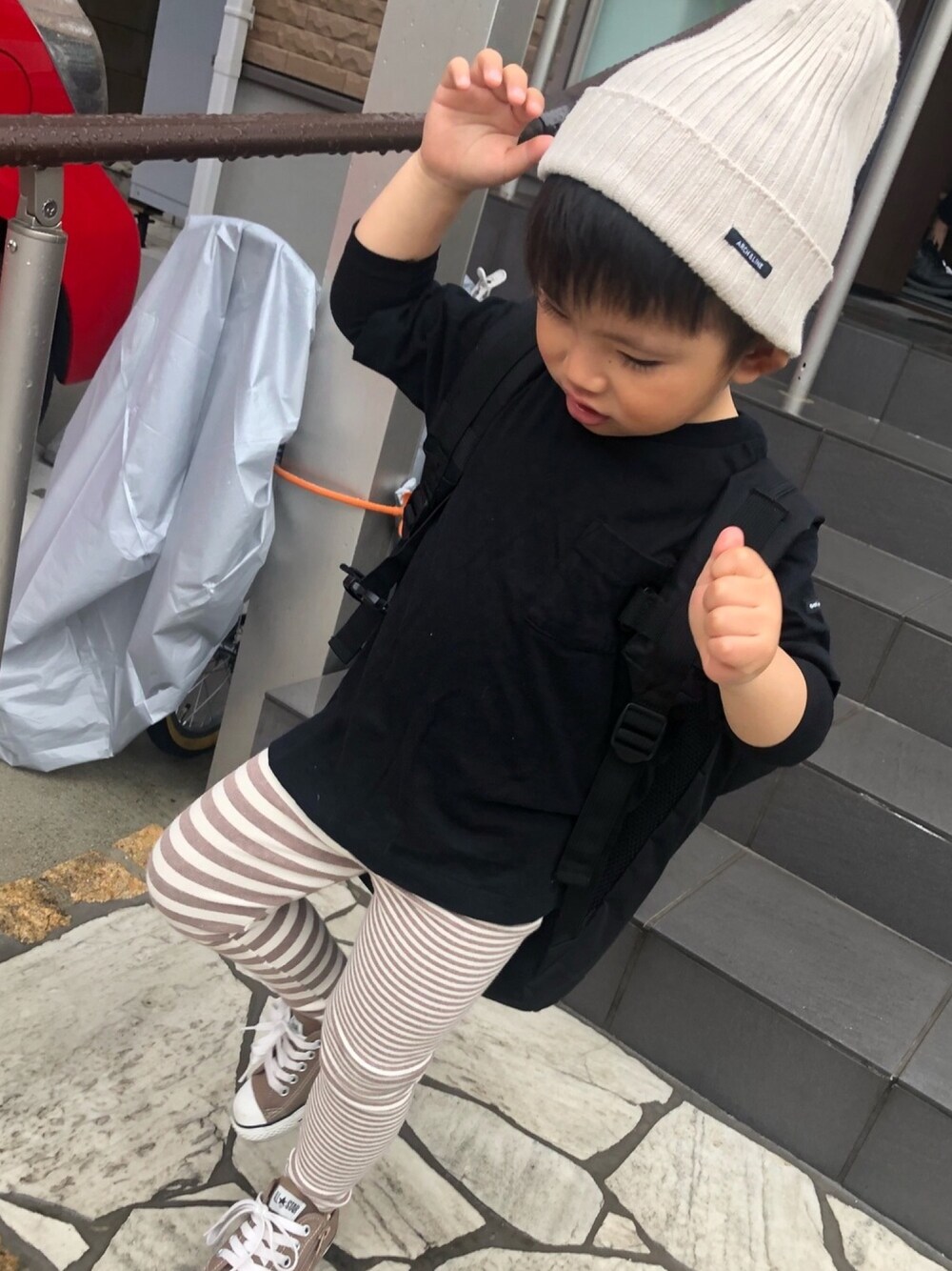 ブラック系のTシャツ/カットソー、ブラウン系のスニーカー、ブラック系のバックパック/リュックを着用したキッズの春コーディネートの1枚目の写真