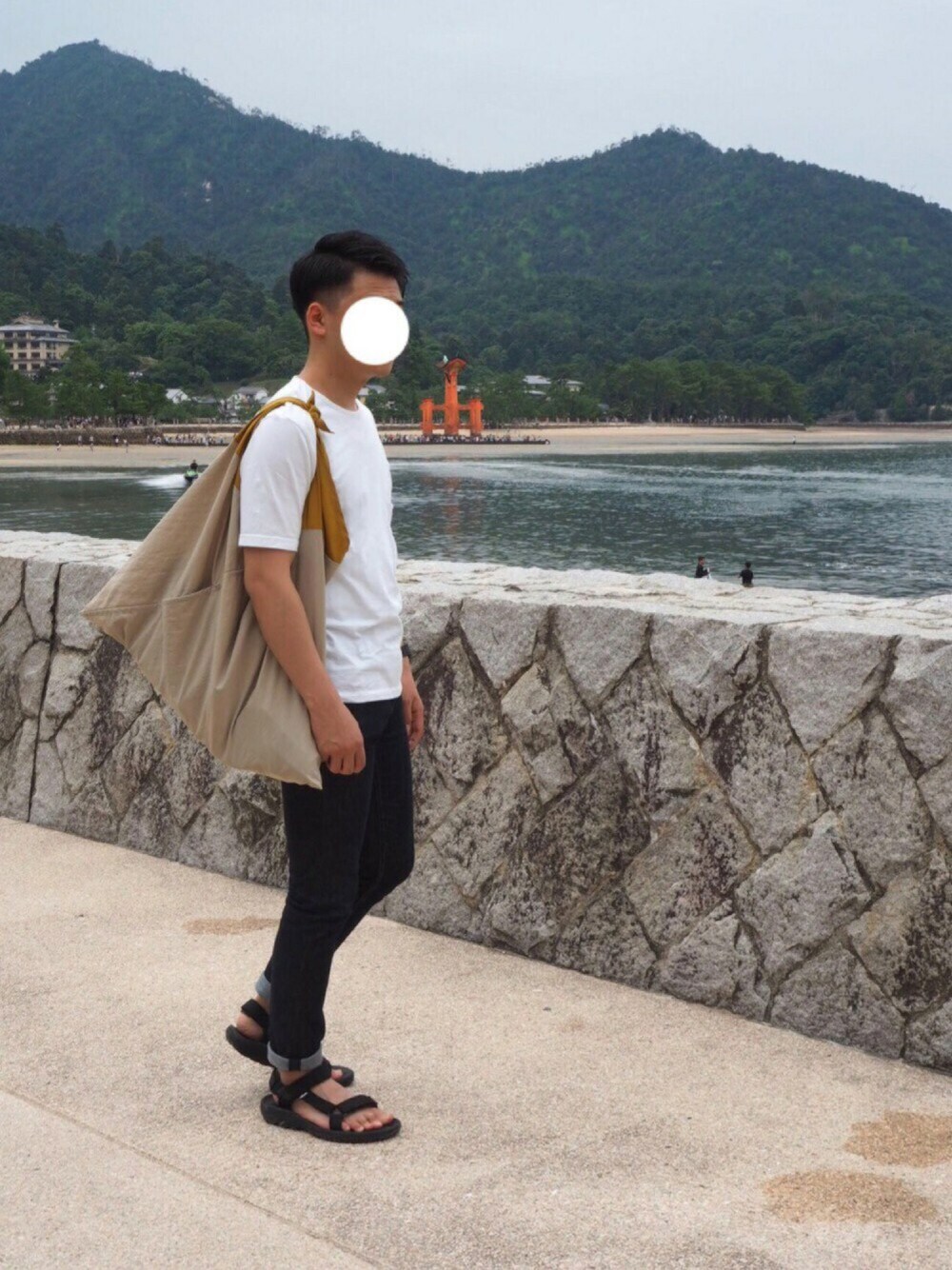 ブルー系のデニムパンツ、ブラック系のサンダルを着用したメンズの夏コーディネートの1枚目の写真