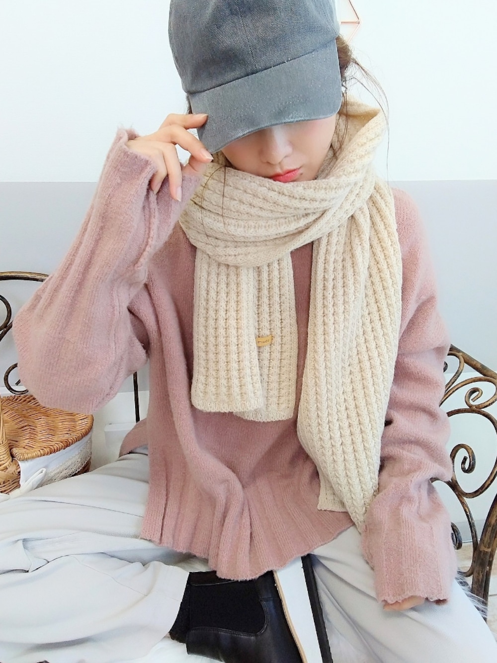 ピンク系のニット/セーター、ベージュ系のマフラー、グレー系のキャップを着用したレディースの冬コーディネートの1枚目の写真