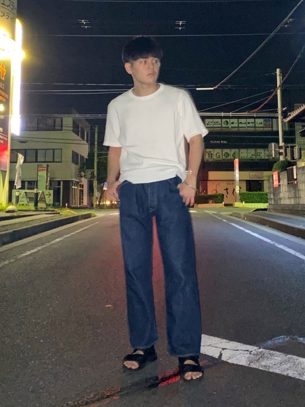 ブルー系のデニムパンツ、ブラック系のサンダル、ホワイト系のTシャツ/カットソーを着用したメンズの秋コーディネートの1枚目の写真