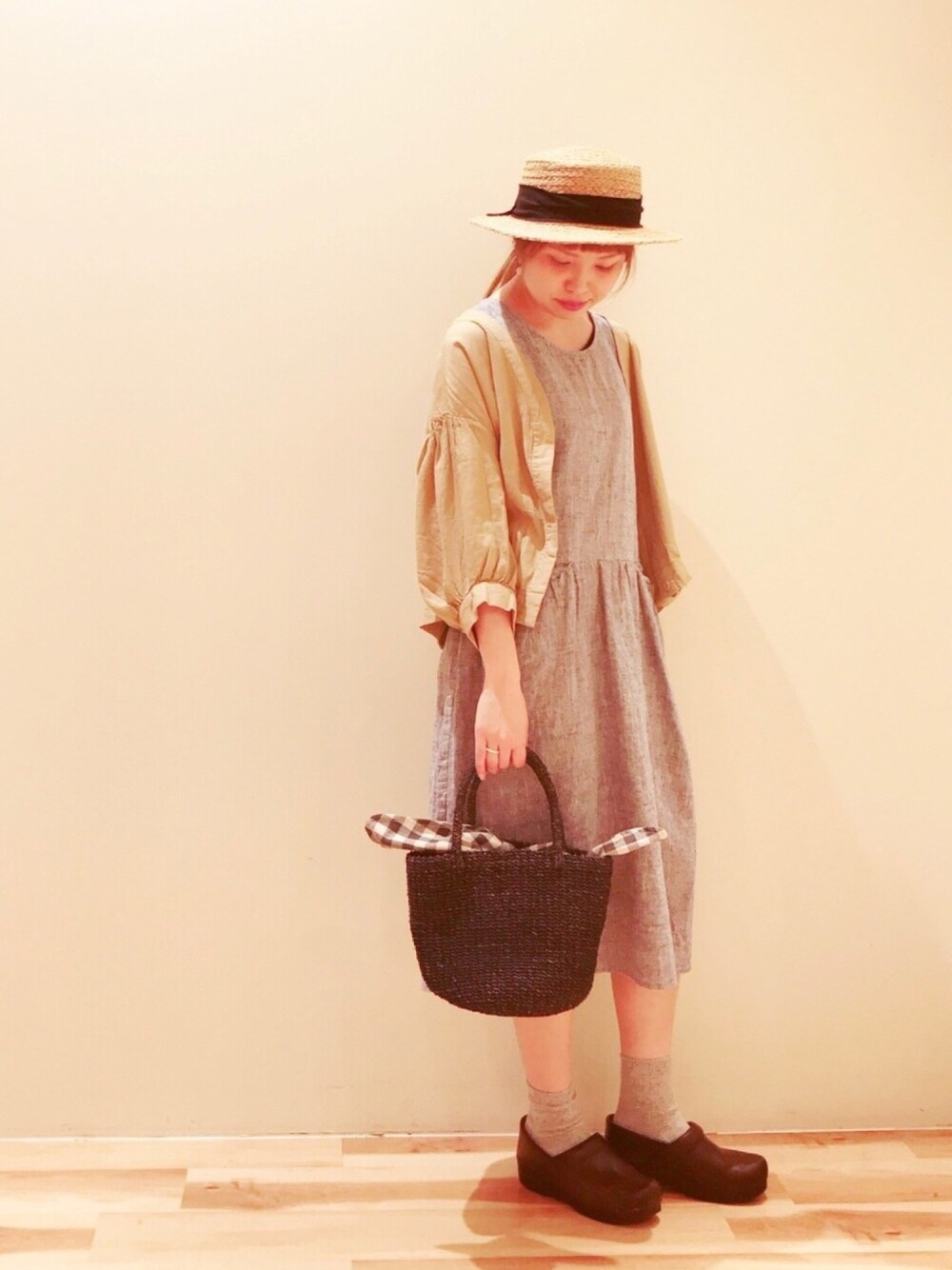 ブルー系のかごバッグ、ブルー系のワンピース、ベージュ系のブルゾンを着用したレディースの春コーディネートの1枚目の写真