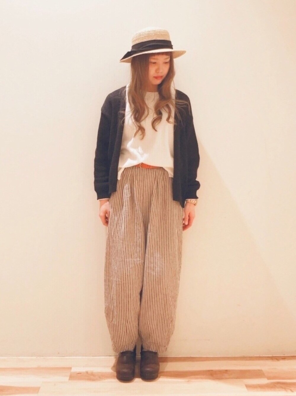 ブラック系のニット/セーター、ホワイト系のTシャツ/カットソー、ブラック系のその他パンツを着用したレディースの春コーディネートの1枚目の写真