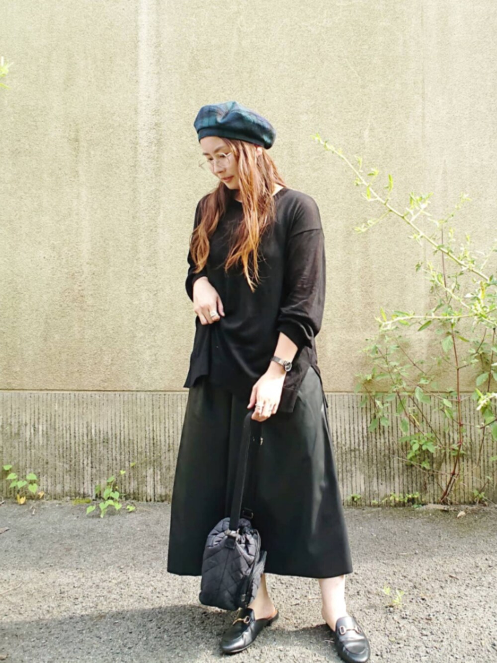 ブラック系のスカート、ブラック系のバッグを着用したレディースの夏コーディネートの1枚目の写真