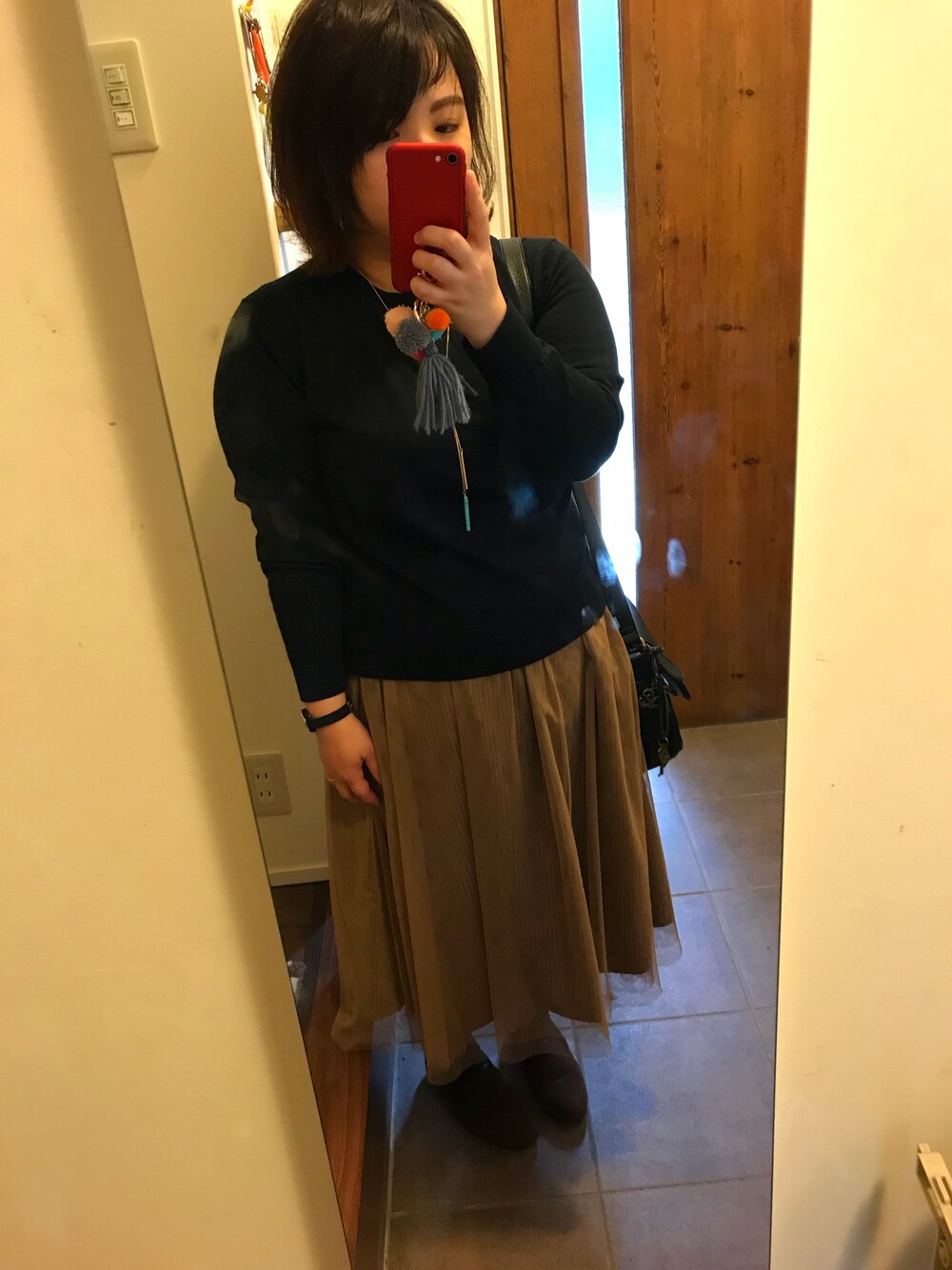 ブルー系のニット/セーター、ブラウン系のバッグ、ベージュ系のスカートを着用したレディースの秋コーディネートの1枚目の写真