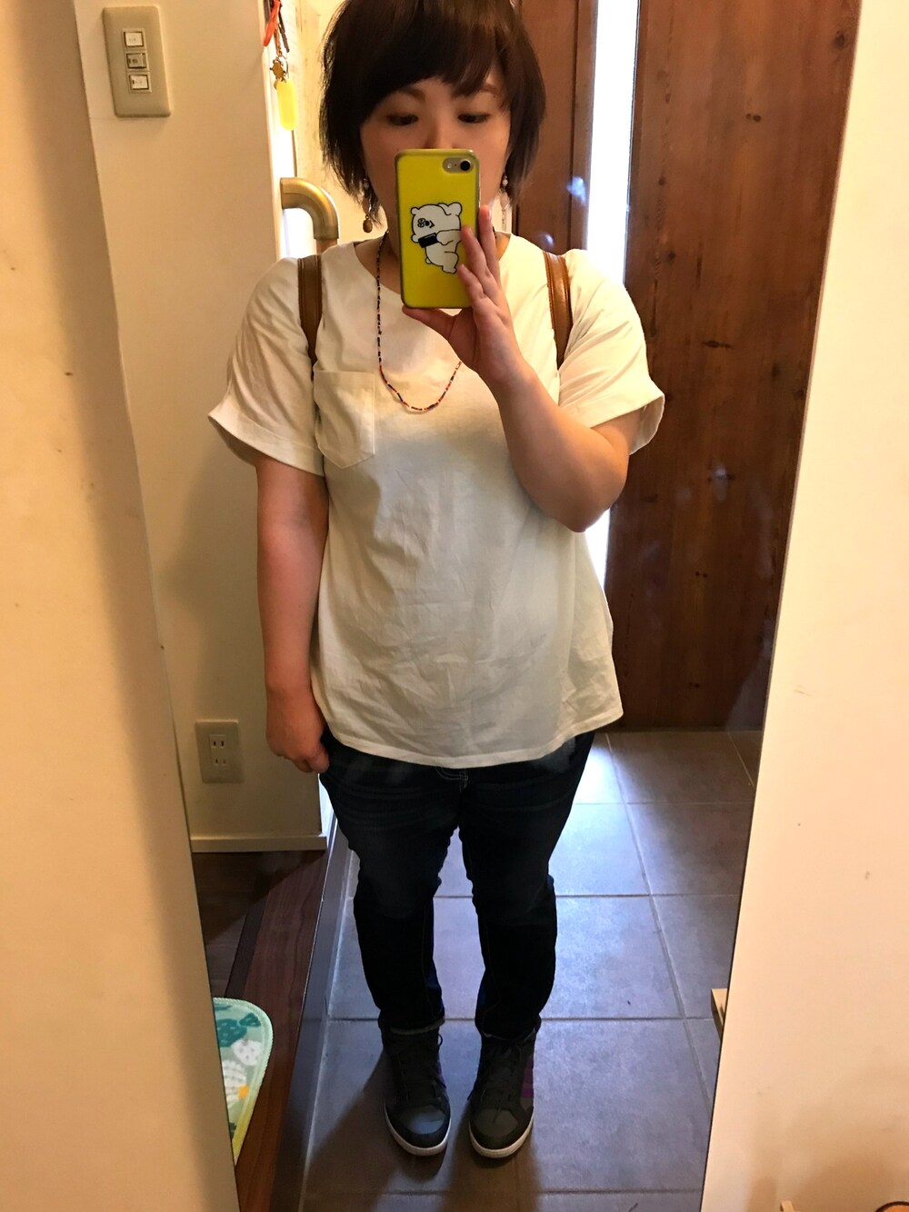 ブラウン系のバックパック/リュック、ホワイト系のTシャツ/カットソー、ブルー系のデニムパンツを着用したレディースの夏コーディネートの1枚目の写真