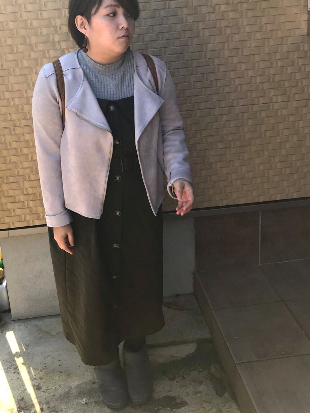 ブラウン系のバックパック/リュック、ベージュ系のライダースジャケット、グリーン系のワンピース/ドレスを着用したレディースの秋コーディネートの1枚目の写真