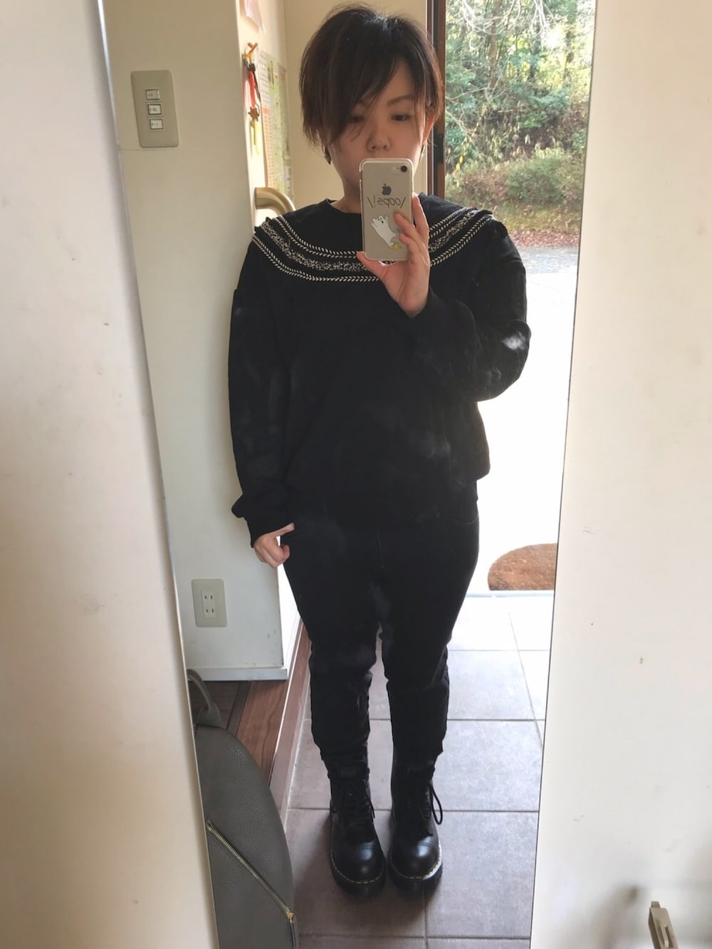 ブラック系のスウェット、ブラック系のデニムパンツ、グレー系のバックパック/リュックを着用したレディースの春コーディネートの1枚目の写真