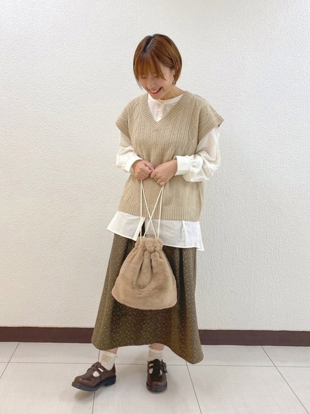 ブラウン系のドレスシューズ、ホワイト系のシャツ/ブラウス、ベージュ系のショルダーバッグを着用したレディースの秋コーディネートの1枚目の写真