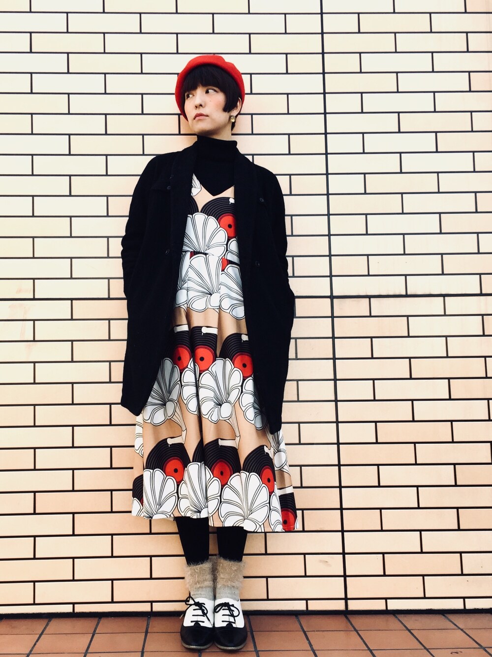 イエロー系のワンピース、ブラック系のその他アウター、ブラック系のニット/セーターを着用したレディースの冬コーディネートの1枚目の写真