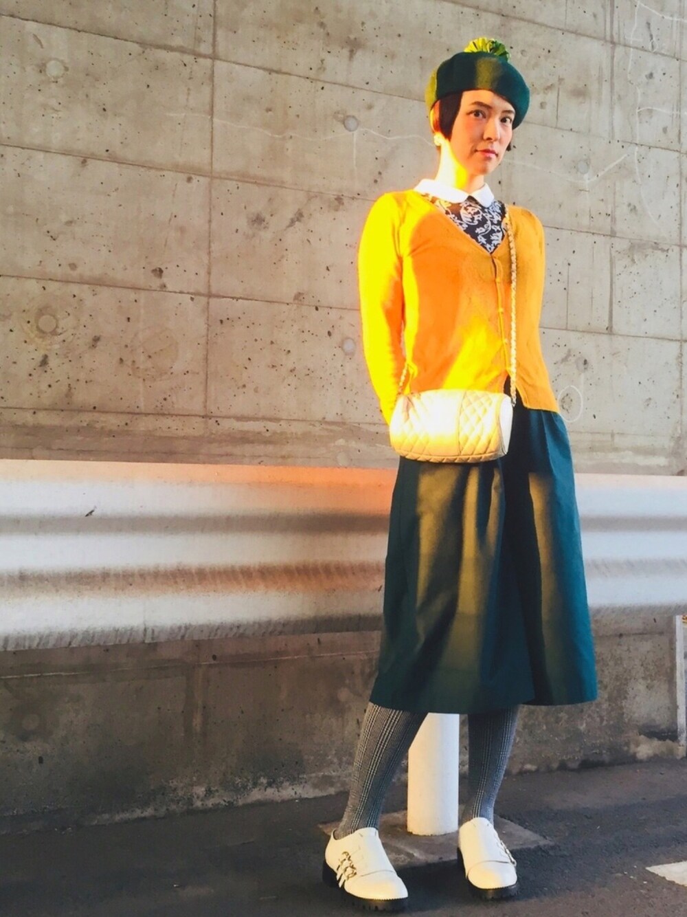 イエロー系のカーディガン/ボレロ、ブラック系のTシャツ/カットソー、ホワイト系のショルダーバッグを着用したレディースの春コーディネートの1枚目の写真