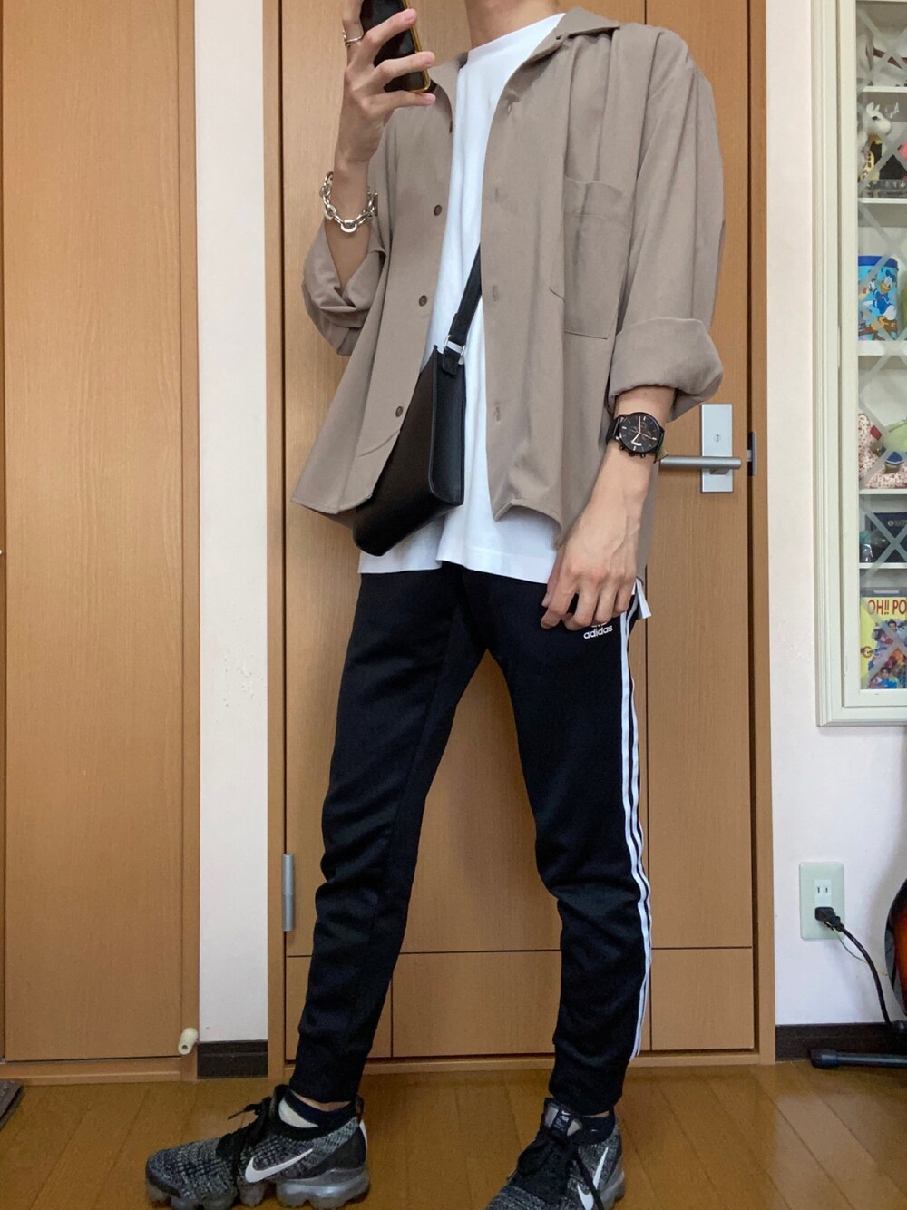 ホワイト系のTシャツ/カットソー、ブラック系のショルダーバッグ、ベージュ系のシャツ/ブラウスを着用したメンズの春コーディネートの1枚目の写真