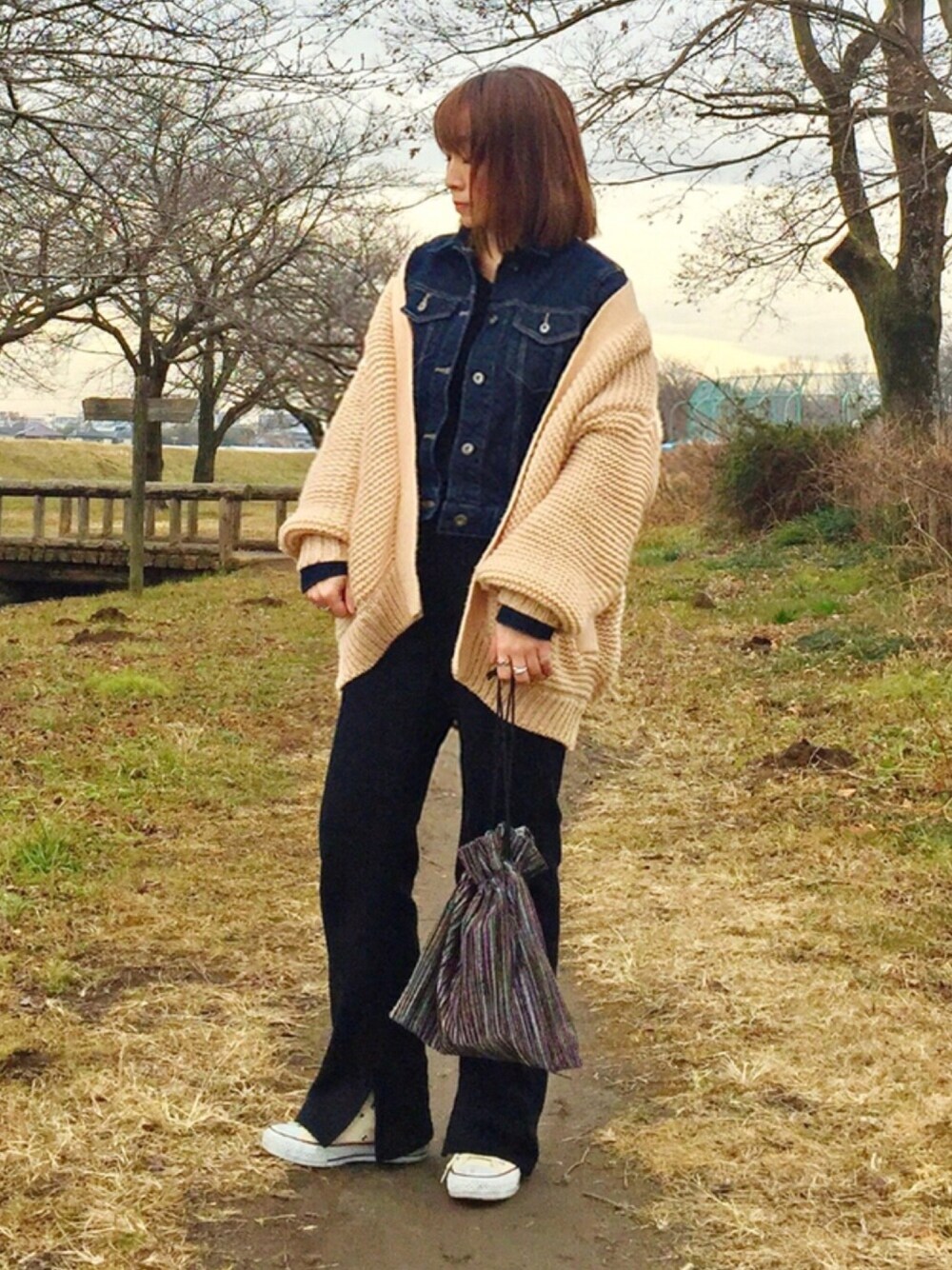 ピンク系のカーディガン/ボレロ、ブルー系のデニムジャケット、ブラック系のニット/セーターを着用したレディースの冬コーディネートの1枚目の写真