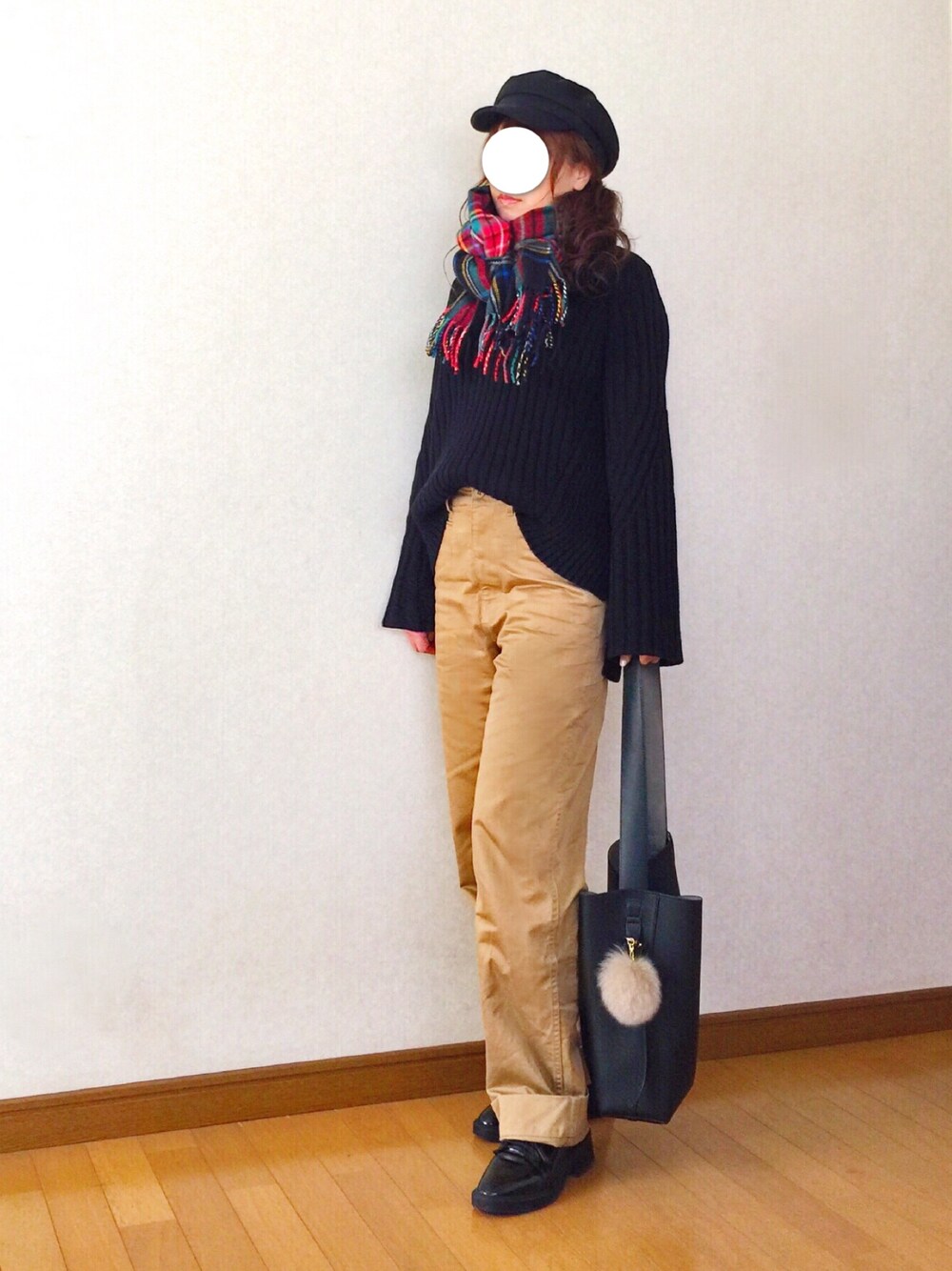 ブラック系のニット/セーター、ベージュ系のチノパンツ、ブラック系のショルダーバッグを着用したレディースの冬コーディネートの1枚目の写真