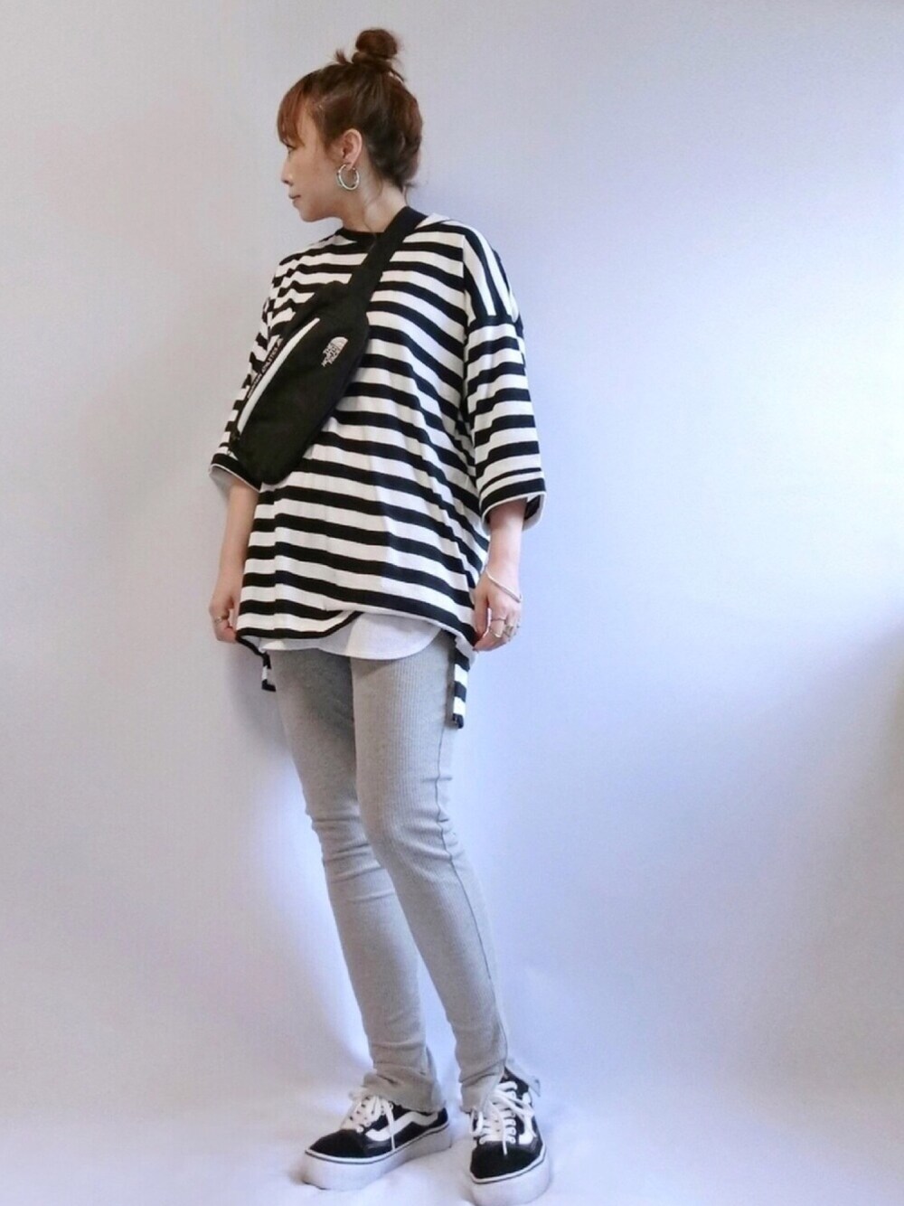 ホワイト系のタンクトップ、ブラック系のボディバッグ/ウエストポーチ、ブラック系のスニーカーを着用したレディースの秋コーディネートの1枚目の写真