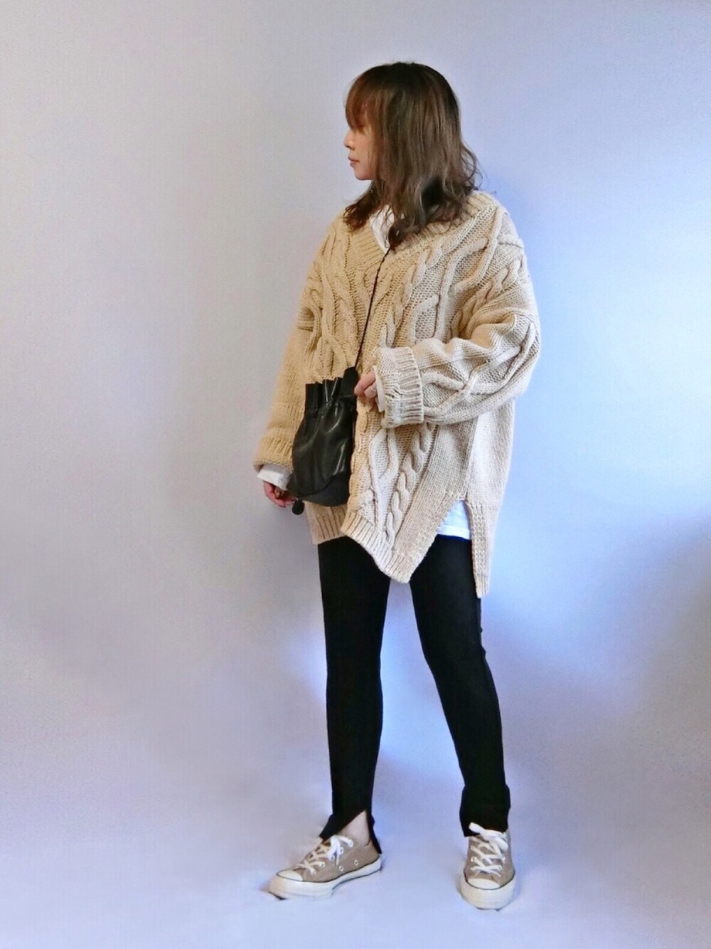 ホワイト系のTシャツ/カットソー、ベージュ系のニット/セーター、ブラック系のバッグを着用したレディースの春コーディネートの1枚目の写真