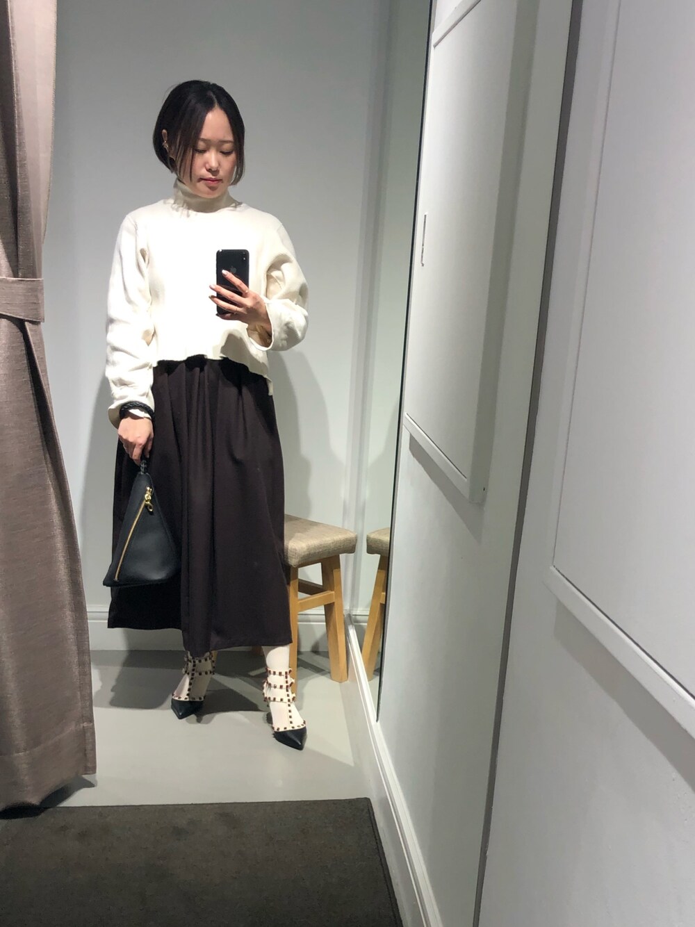 ブラック系のハンドバッグを着用したレディースの春コーディネートの1枚目の写真