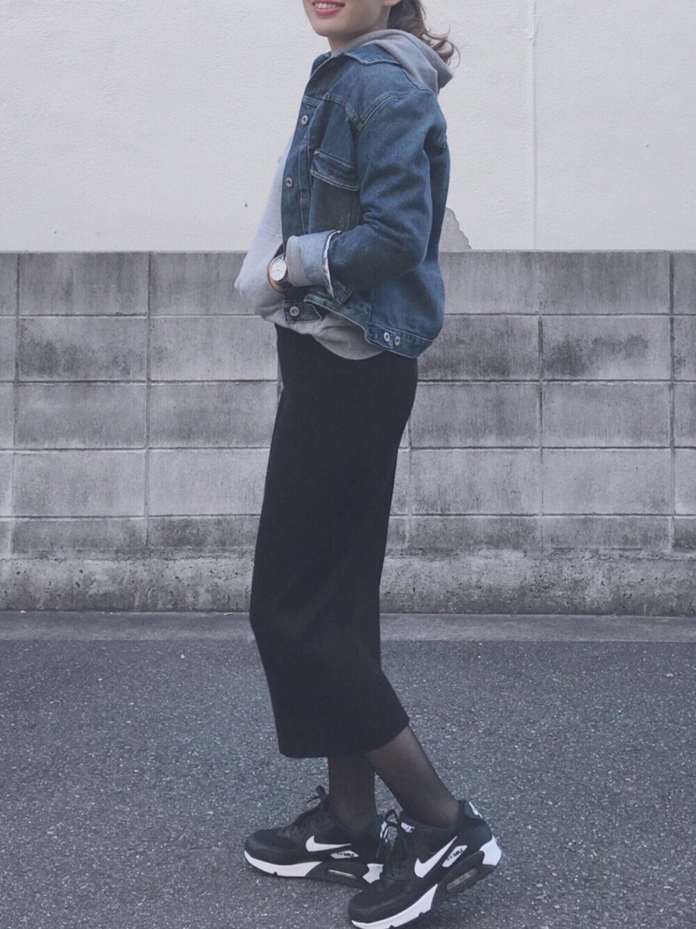 ブラック系のスニーカー、ブラック系のスカート、グレー系のパーカーを着用したレディースの秋コーディネートの1枚目の写真