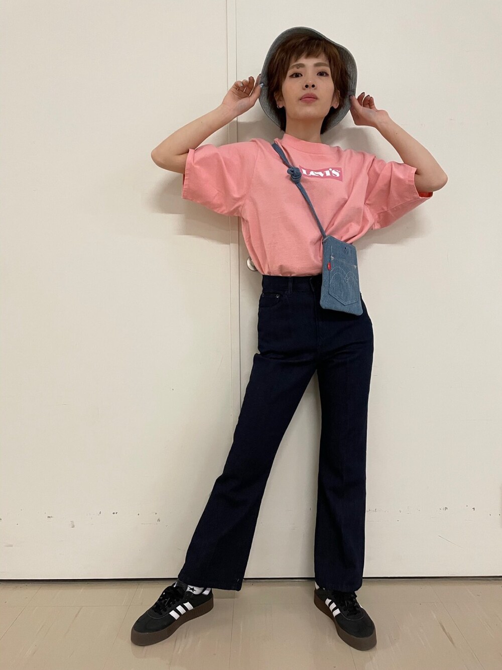 ピンク系のTシャツ/カットソー、ブルー系のショルダーバッグ、ブラック系のデニムパンツを着用したレディースの春コーディネートの1枚目の写真