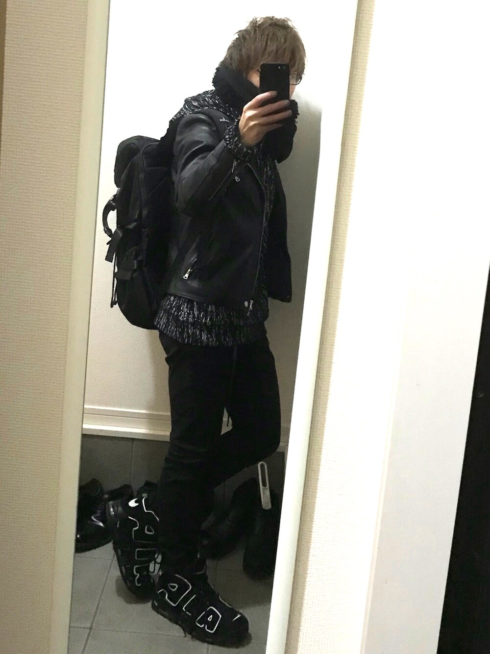 ブラック系のライダースジャケット、ブラック系のパーカー、ブラック系のデニムパンツを着用したメンズの冬コーディネートの1枚目の写真