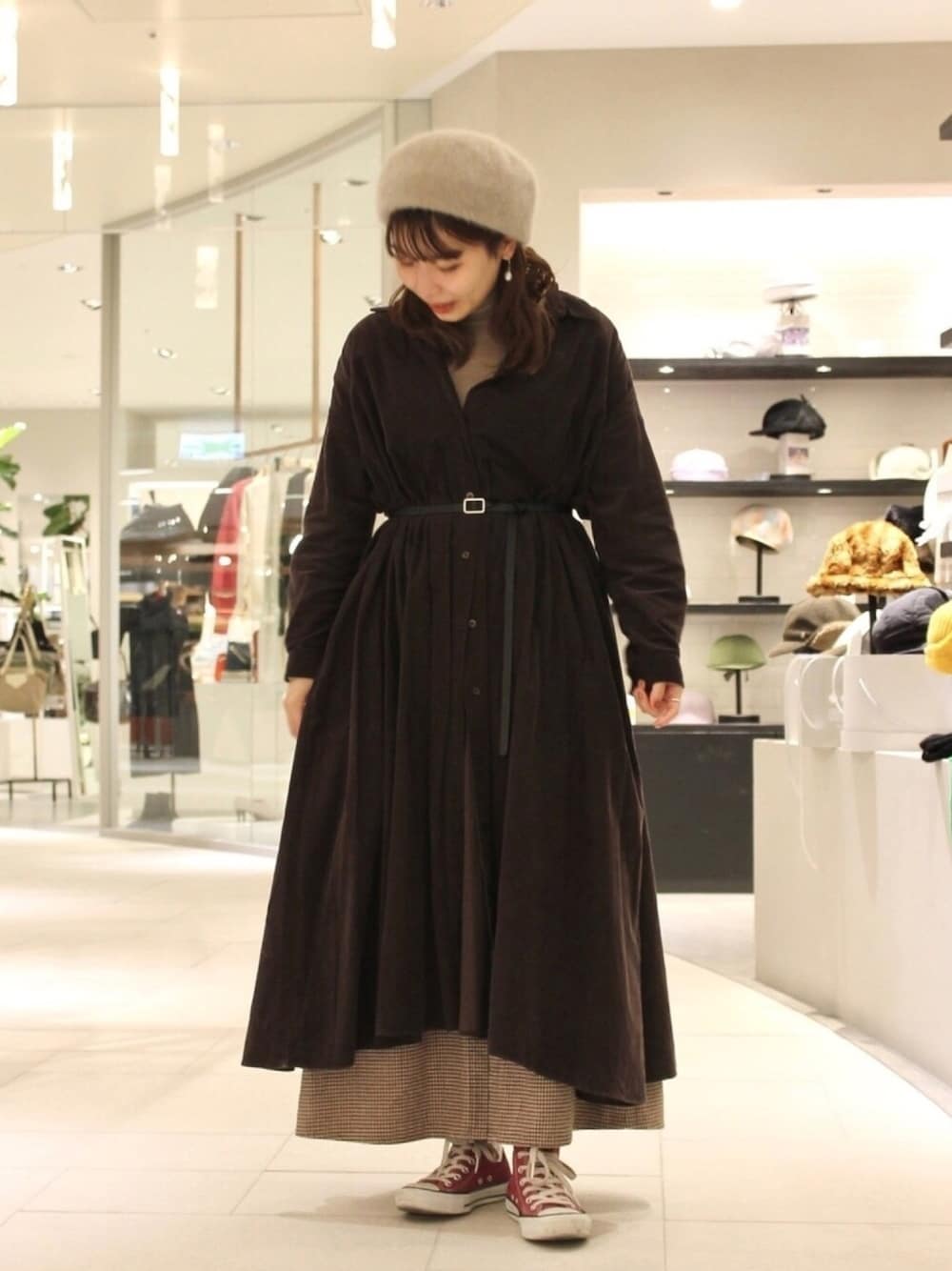 ブラウン系のワンピース、ブラウン系のニット/セーター、レッド系のスニーカーを着用したレディースの冬コーディネートの1枚目の写真