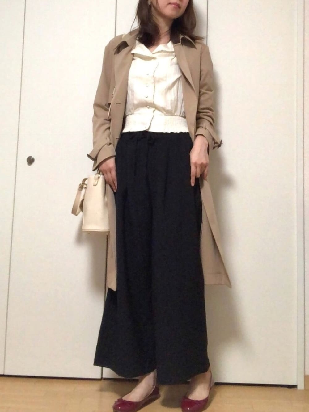 ベージュ系のトレンチコート、ホワイト系のシャツ/ブラウス、ブラック系のその他パンツを着用したレディースの春コーディネートの1枚目の写真