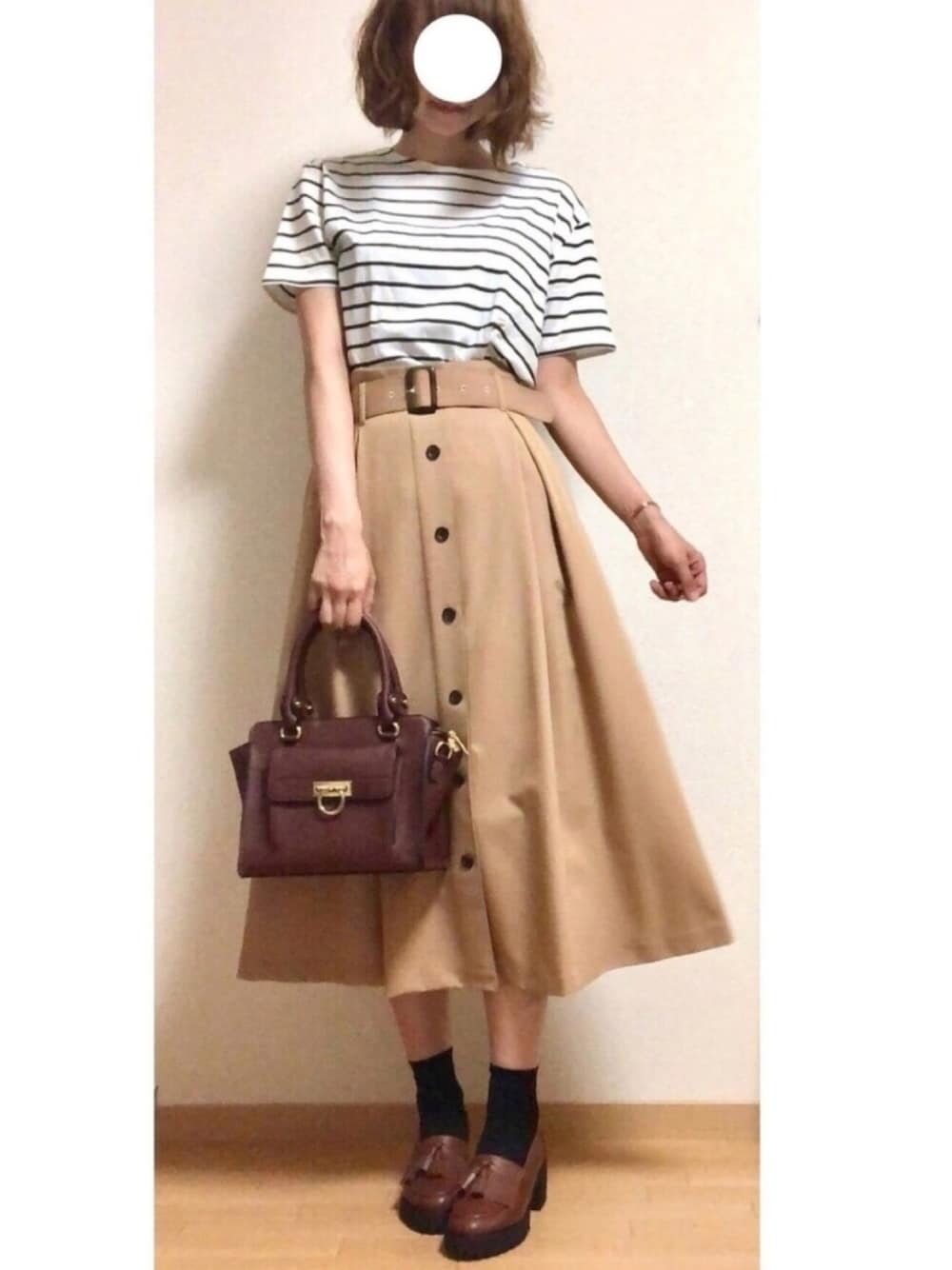 ベージュ系のスカート、ホワイト系のTシャツ/カットソー、ブラウン系のハンドバッグを着用したレディースの夏コーディネートの1枚目の写真