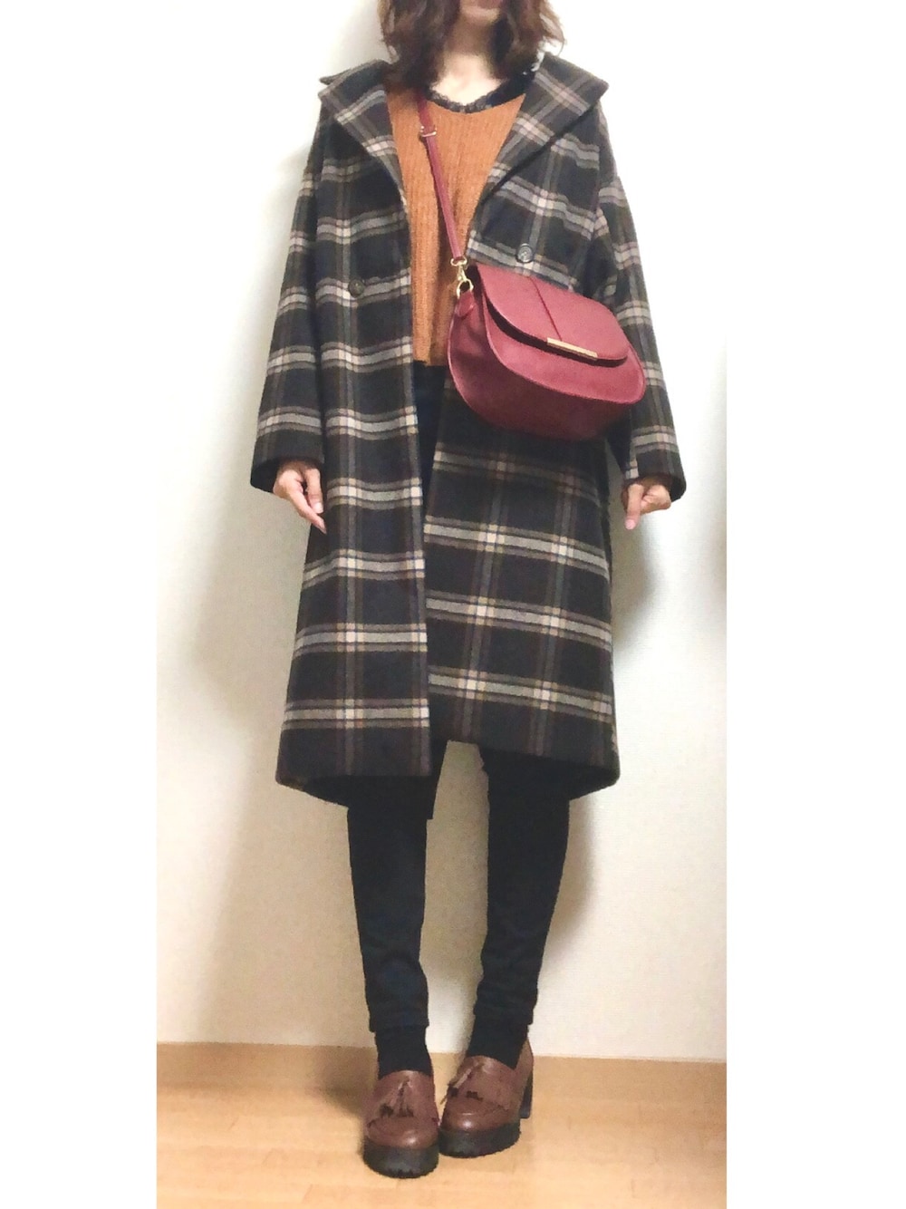 ブラウン系のダウンジャケット/コート、イエロー系のニット/セーター、ブラック系のTシャツ/カットソーを着用したレディースの冬コーディネートの1枚目の写真