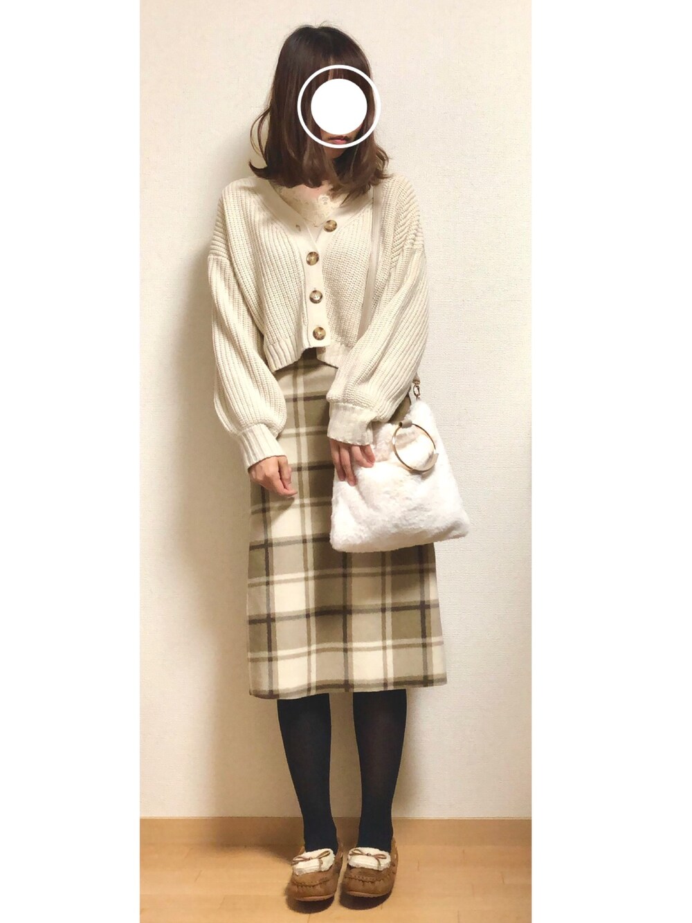 ベージュ系のTシャツ/カットソー、ホワイト系のカーディガン/ボレロ、ベージュ系のスカートを着用したレディースの冬コーディネートの1枚目の写真