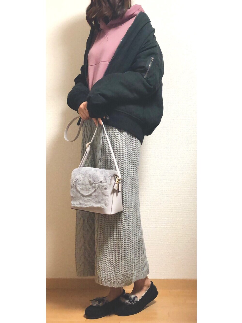 ピンク系のパーカー、ブラック系のMA-1、グレー系のスカートを着用したレディースの冬コーディネートの1枚目の写真