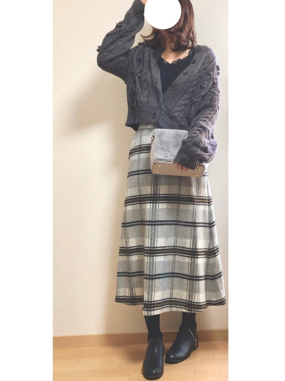 ブラック系のTシャツ/カットソー、ブラック系のカーディガン/ボレロ、ホワイト系のスカートを着用したレディースの冬コーディネートの1枚目の写真