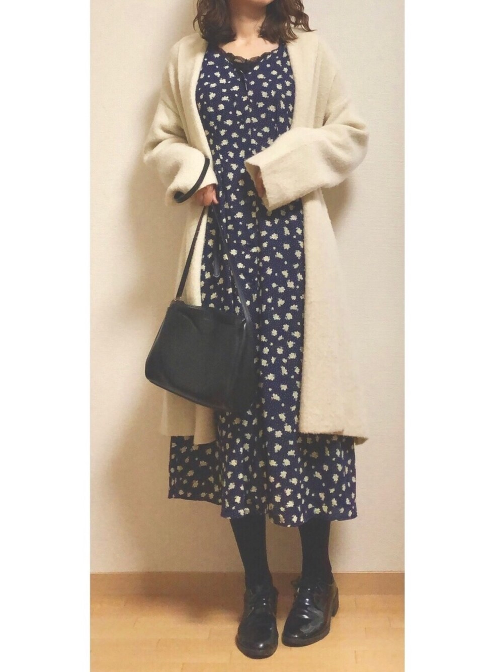 ブラック系のTシャツ/カットソー、ブルー系のワンピース、ベージュ系のカーディガン/ボレロを着用したレディースの冬コーディネートの1枚目の写真