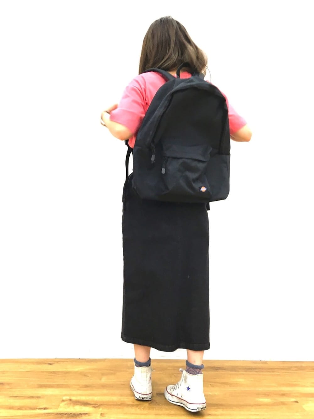 ピンク系のTシャツ/カットソー、ブルー系のデニムスカート、ホワイト系のスニーカーを着用したレディースの春コーディネートの1枚目の写真