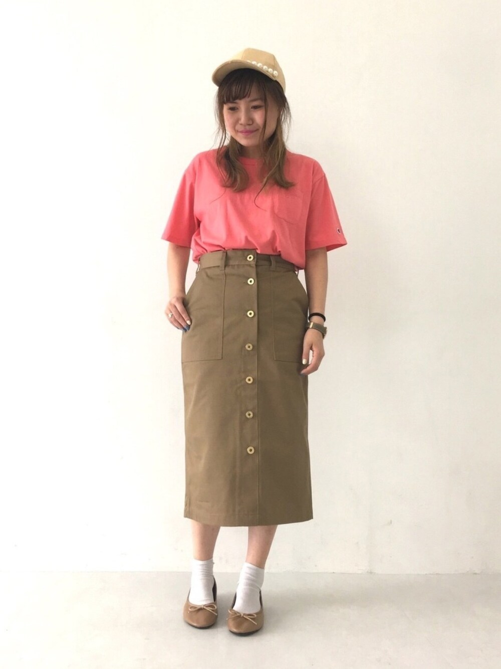 ピンク系のTシャツ/カットソー、ベージュ系のスカート、ベージュ系のキャップを着用したレディースの春コーディネートの1枚目の写真
