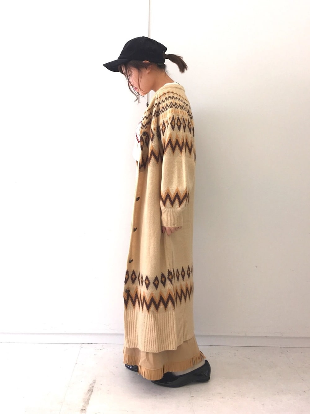 ベージュ系のダウンジャケット/コート、レッド系のスカート、ホワイト系のニット/セーターを着用したレディースの冬コーディネートの1枚目の写真