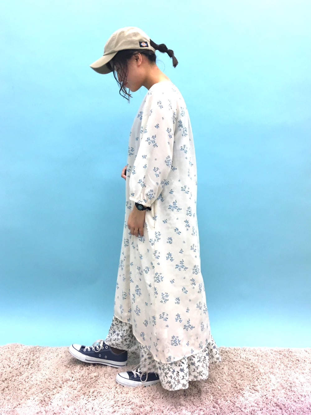 ベージュ系のワンピース、ホワイト系のスカート、ブラック系のスニーカーを着用したレディースの冬コーディネートの1枚目の写真