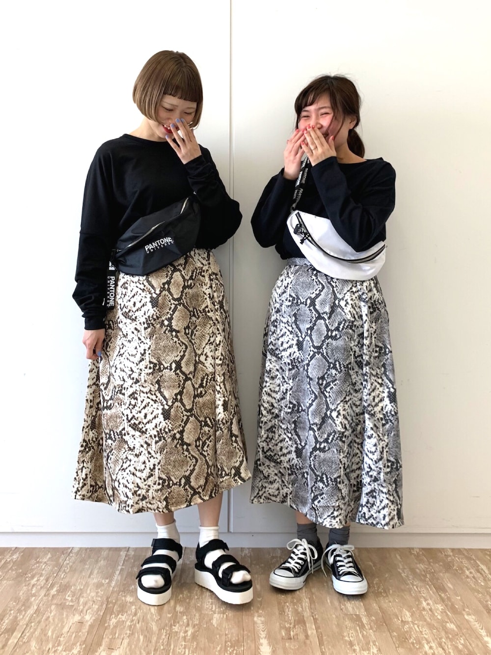 グレー系のスカート、ブラック系のTシャツ/カットソー、ホワイト系のボディバッグ/ウエストポーチを着用したレディースの冬コーディネートの1枚目の写真