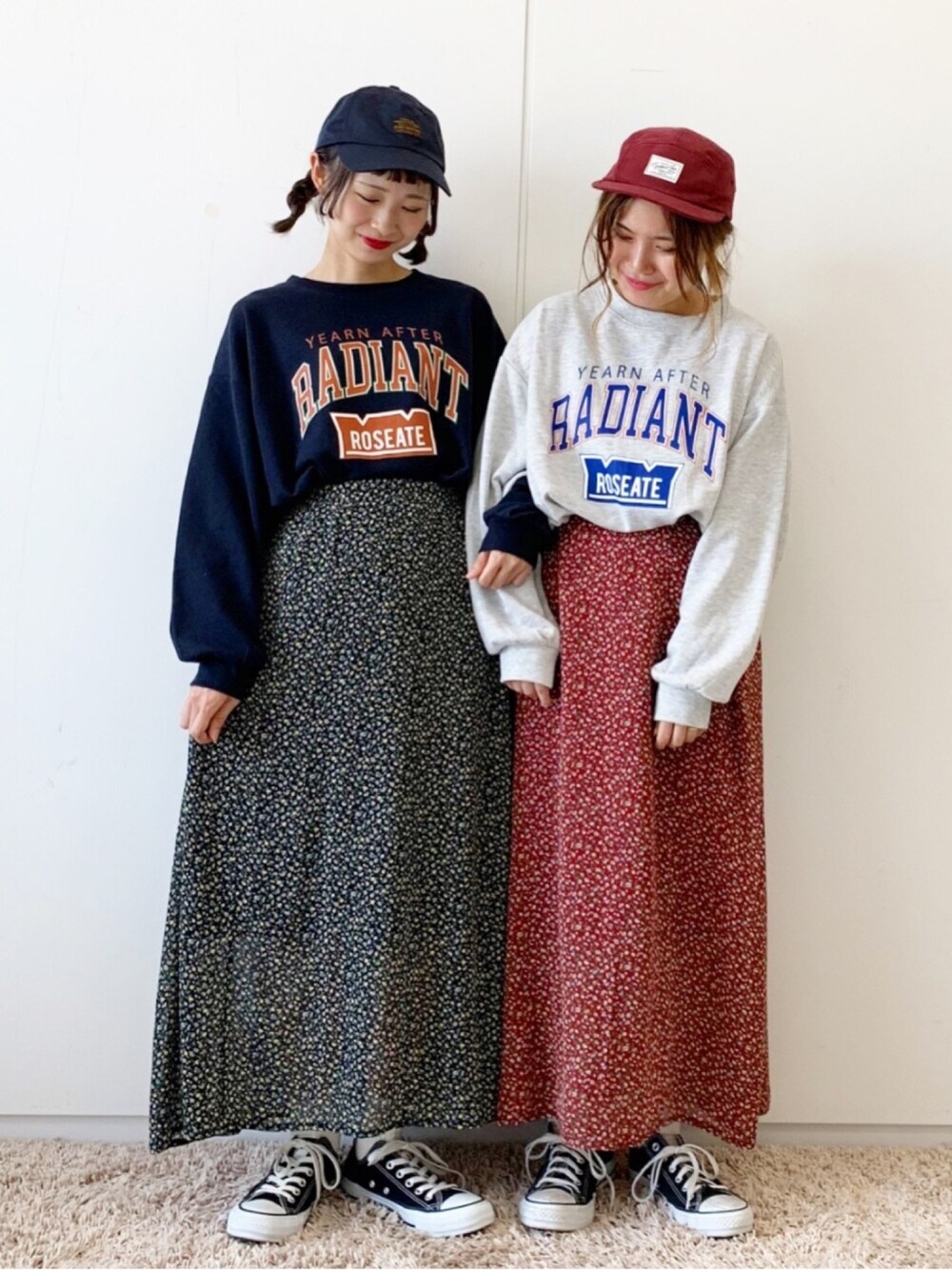 グレー系のTシャツ/カットソー、レッド系のスカート、ブラック系のスニーカーを着用したレディースの秋コーディネートの1枚目の写真