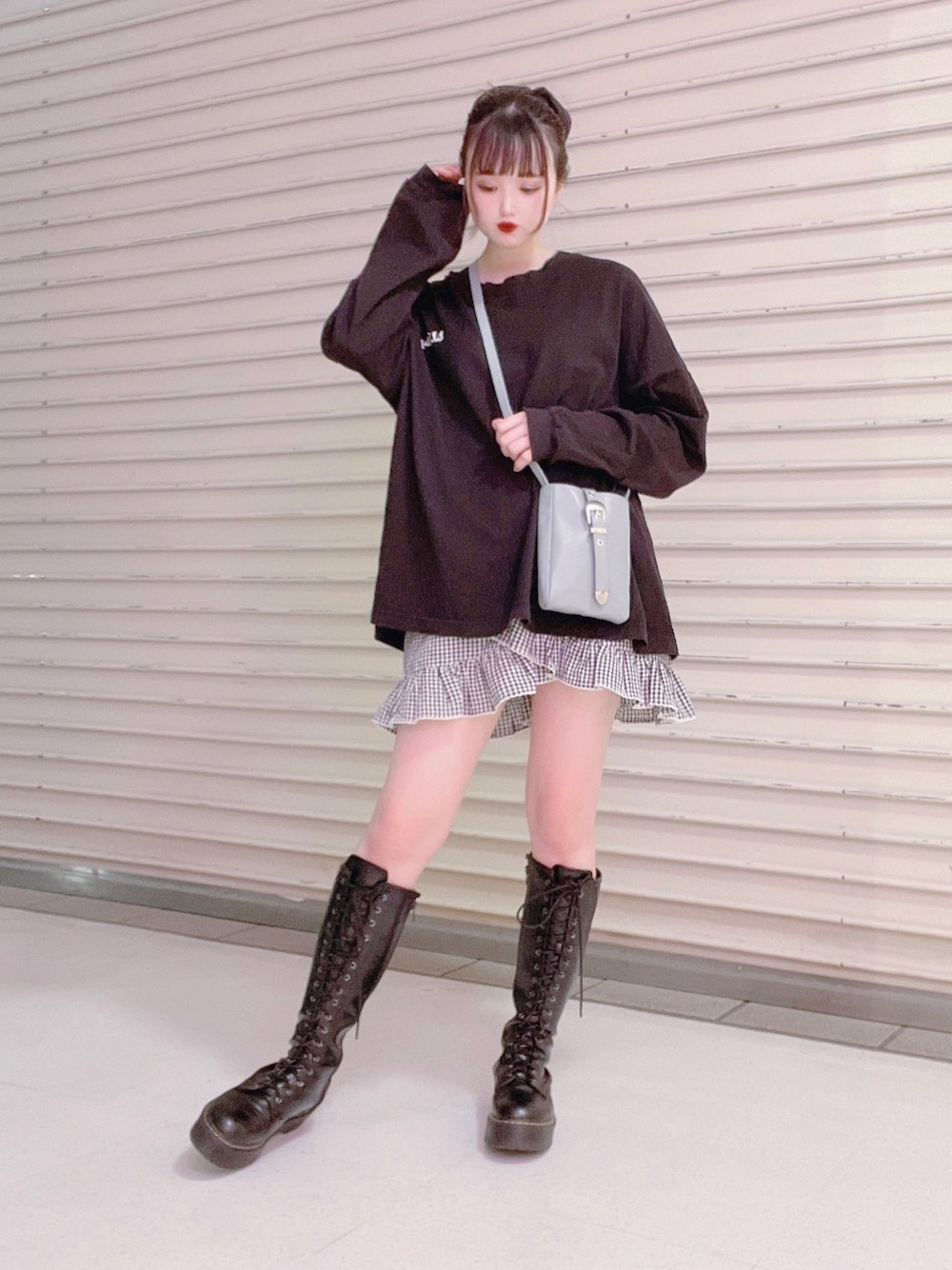 ブラック系のスカート、ブラック系のTシャツ/カットソー、ブラック系のブーツを着用したレディースの春コーディネートの1枚目の写真