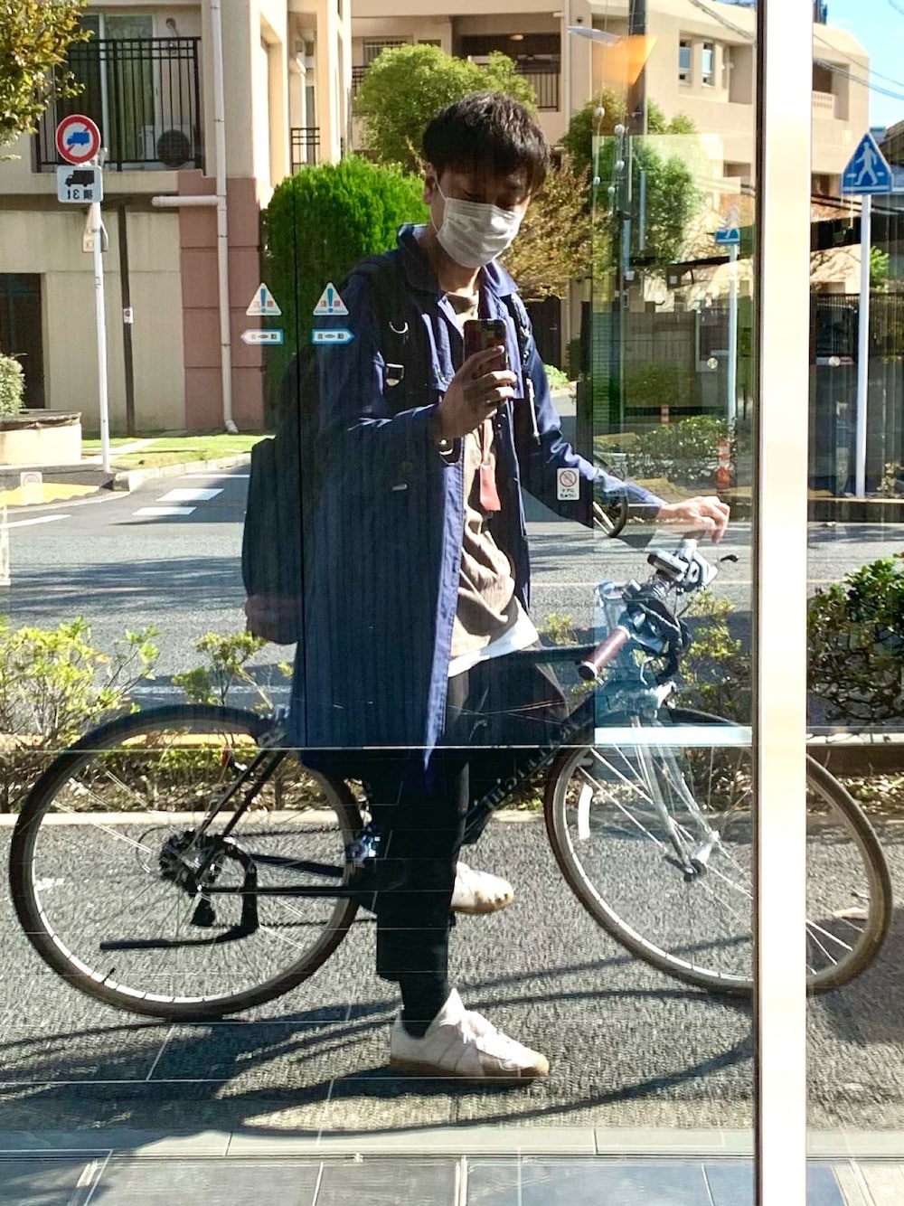 「トレンチコート、ステンカラーコート、レイヤードスタイル、スラックス、スニーカー、ジャーマントレーナー、リュック」｜「UNDERCOVERのアイテム（ステンカラーコート、ブルー系）」を使った、SINNEDさん（メンズ・175cm）の秋コーディネートの1枚目の写真