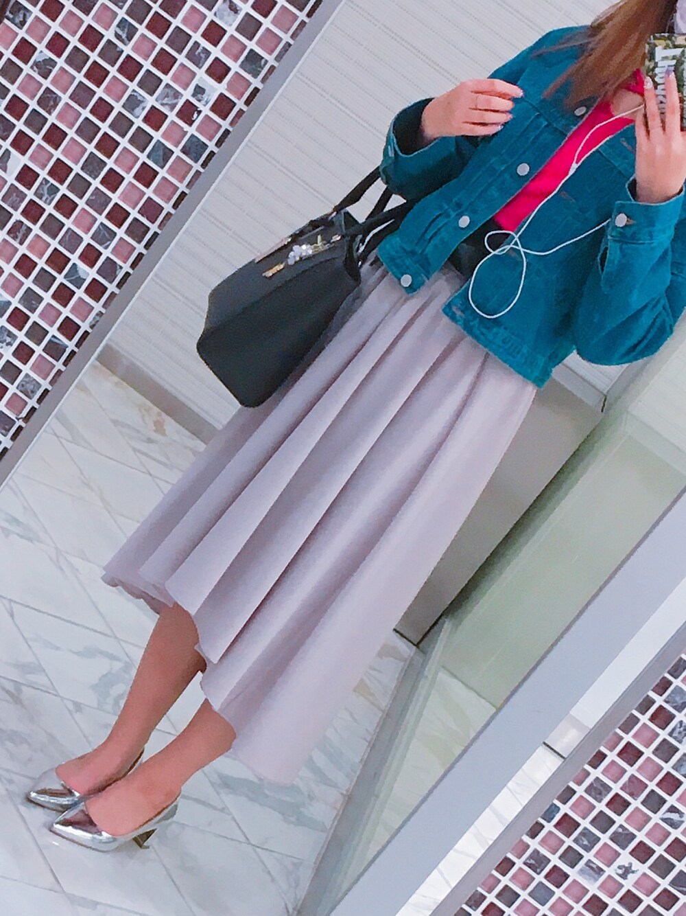 ベージュ系のスカート、シルバー系のパンプス、ブラック系のハンドバッグを着用したレディースの春コーディネートの1枚目の写真