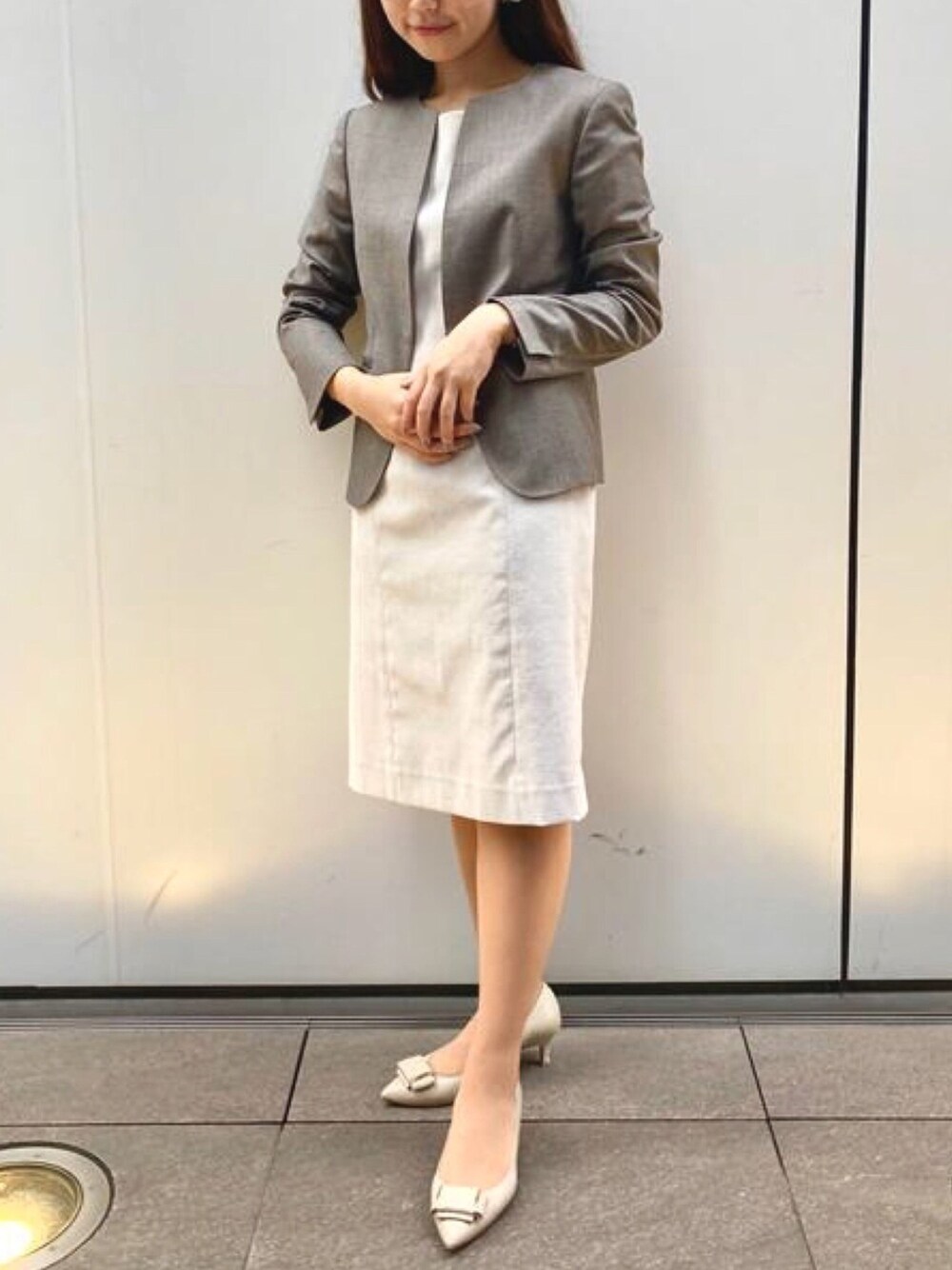 ベージュ系のワンピース、ブラウン系のスーツジャケットを着用したレディースの春コーディネートの1枚目の写真