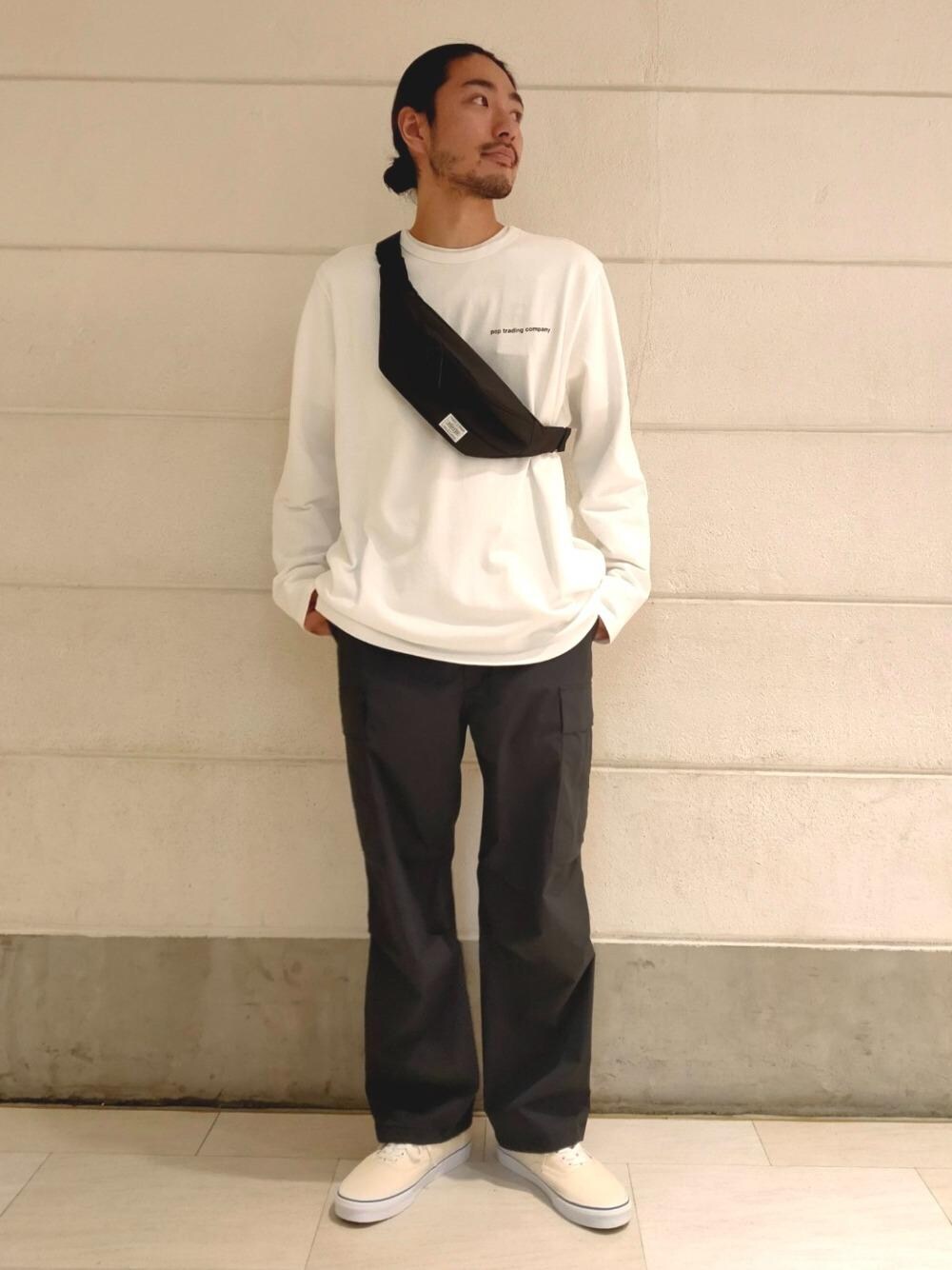 ブラック系のショルダーバッグ、ブラック系のカーゴパンツ、ホワイト系のスニーカーを着用したメンズの春コーディネートの1枚目の写真