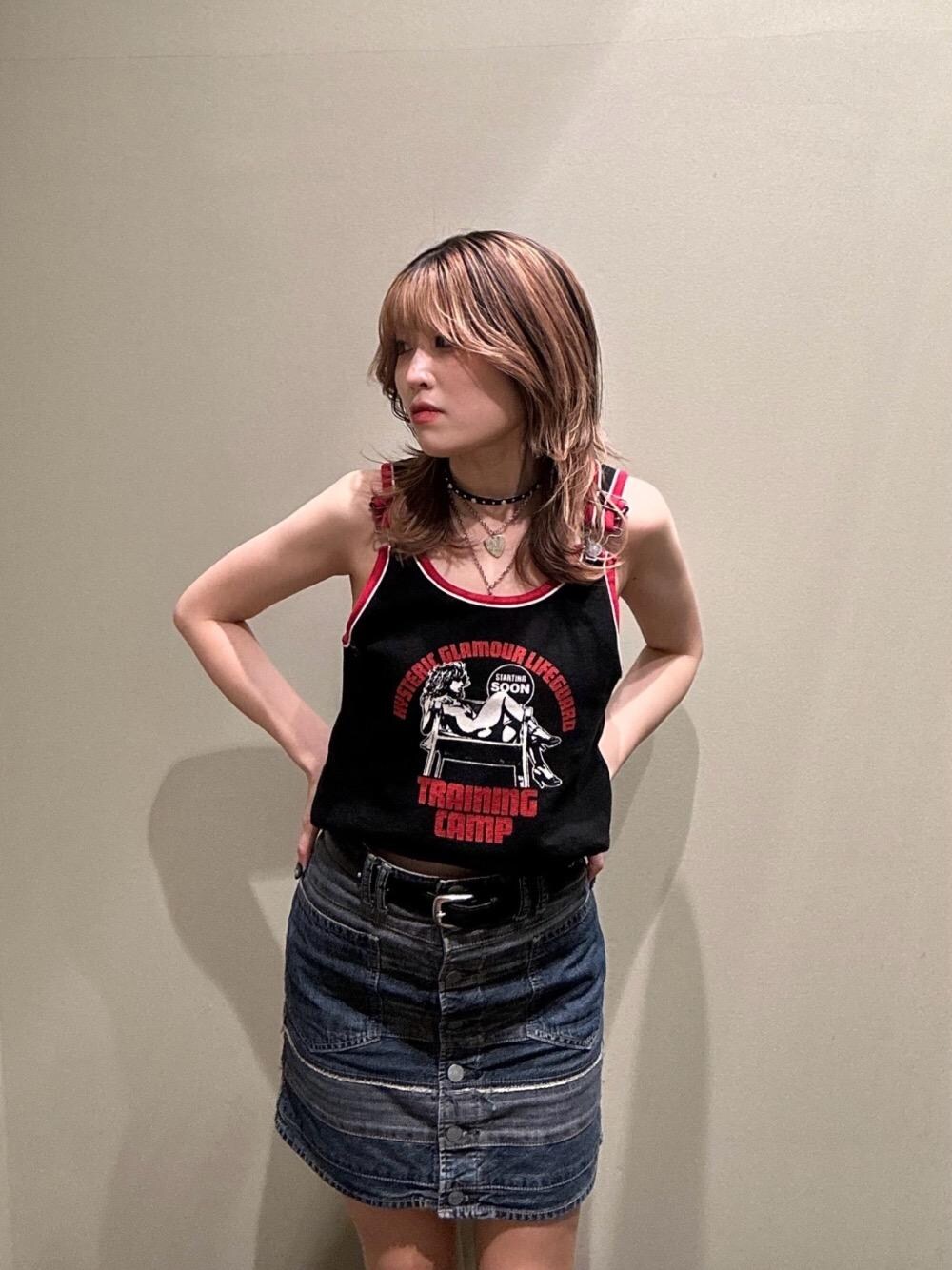 ブルー系のデニムスカート、ブラック系のタンクトップ、ブラック系のベルトを着用したレディースの春コーディネートの1枚目の写真