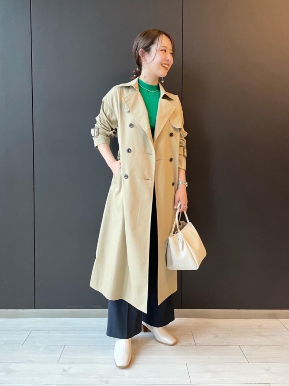 ベージュ系のトレンチコート、グリーン系のカーディガン/ボレロ、ホワイト系のショルダーバッグを着用したレディースの秋コーディネートの1枚目の写真