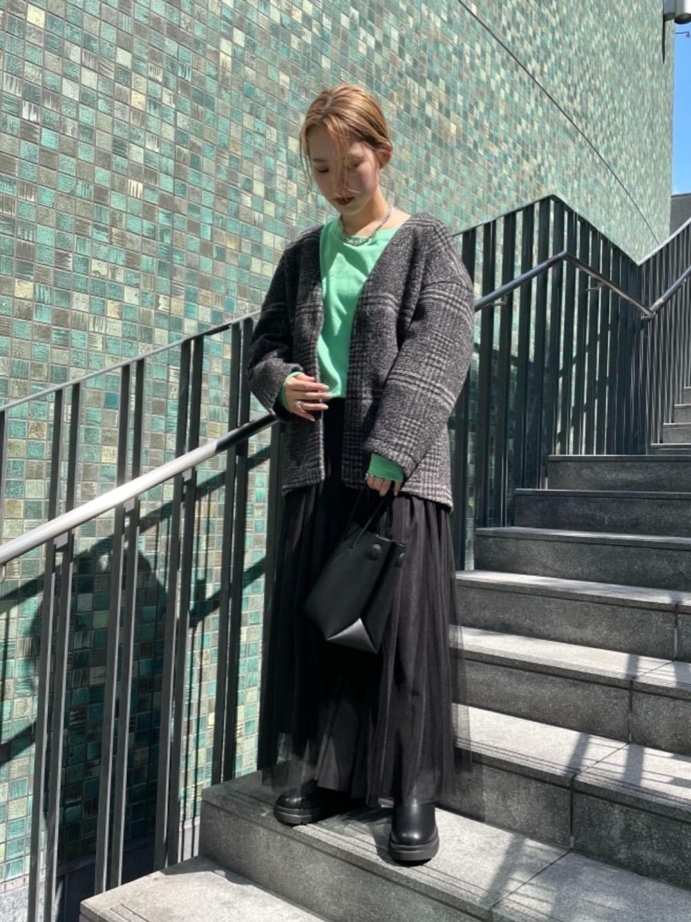 ブラック系のレインシューズ、ブラック系のショルダーバッグ、グリーン系のTシャツ/カットソーを着用したレディースの秋コーディネートの1枚目の写真