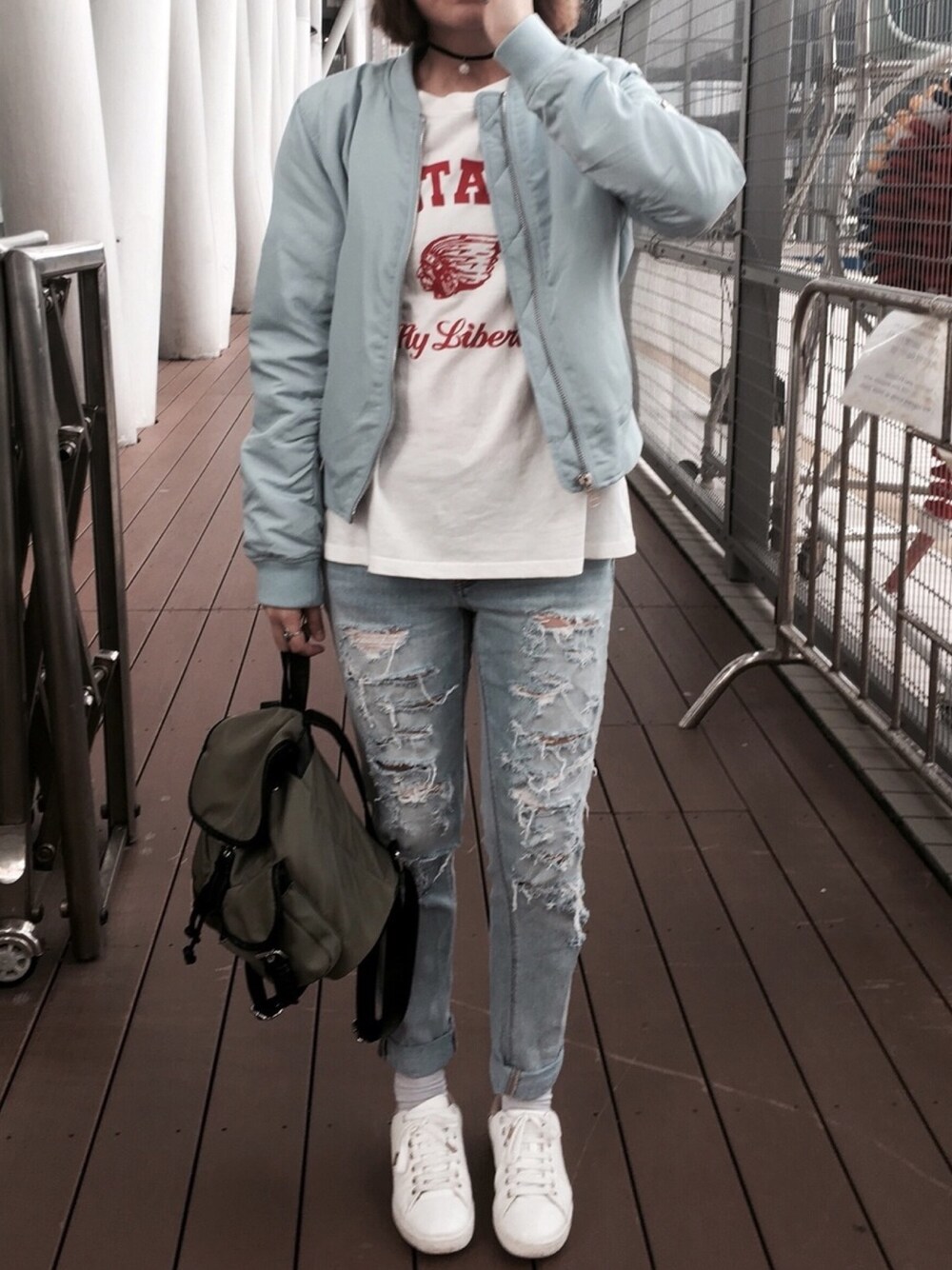 ホワイト系のTシャツ/カットソー、ブルー系のミリタリージャケット、ブルー系のデニムパンツを着用したレディースの秋コーディネートの1枚目の写真