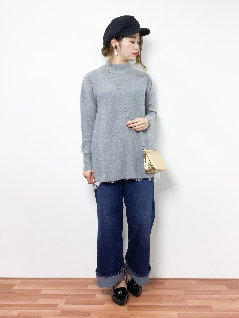 ブルー系のデニムパンツ、グレー系のニット/セーター、ブラック系のパンプスを着用したレディースの冬コーディネートの1枚目の写真
