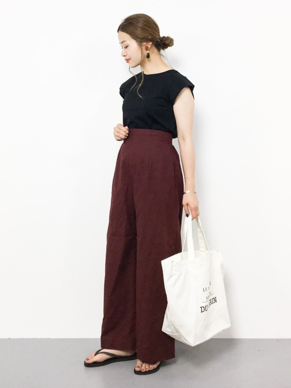 ブラック系のTシャツ/カットソー、ブラウン系のその他パンツ、ホワイト系のショルダーバッグを着用したレディースの夏コーディネートの1枚目の写真