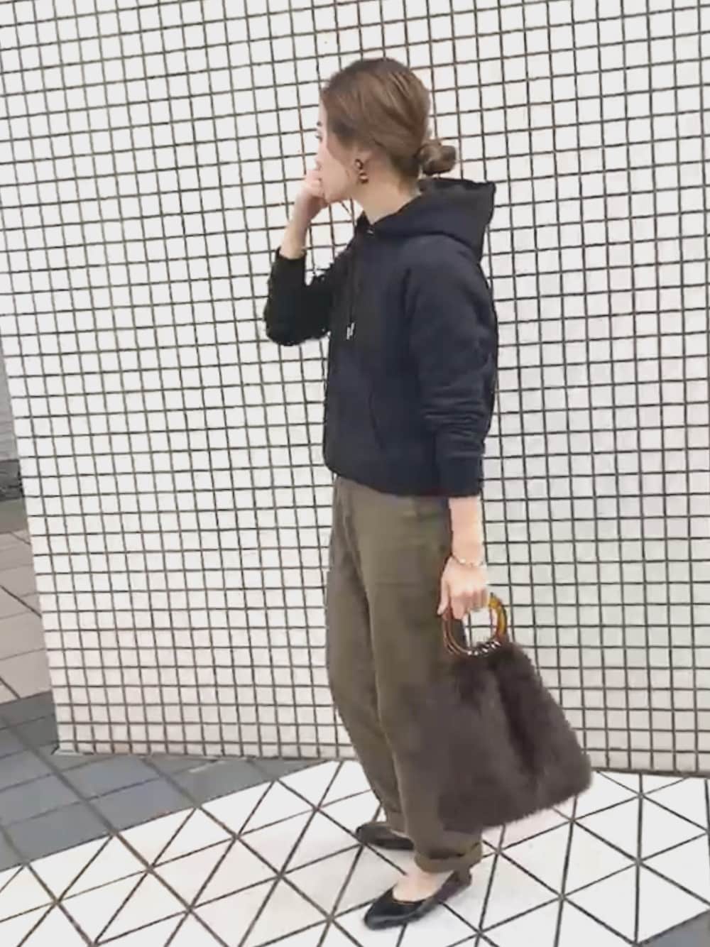 ブラック系のトップス、グリーン系のその他パンツ、ブラウン系のショルダーバッグを着用したレディースの秋コーディネートの1枚目の写真