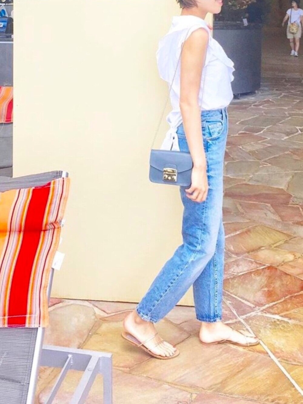 ブルー系のデニムパンツ、ホワイト系のシャツ/ブラウス、ブルー系のショルダーバッグを着用したレディースの夏コーディネートの1枚目の写真
